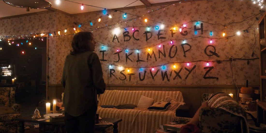 Joyce ante el muro del alfabeto y sus guirnaldas encendidas en Stranger Things