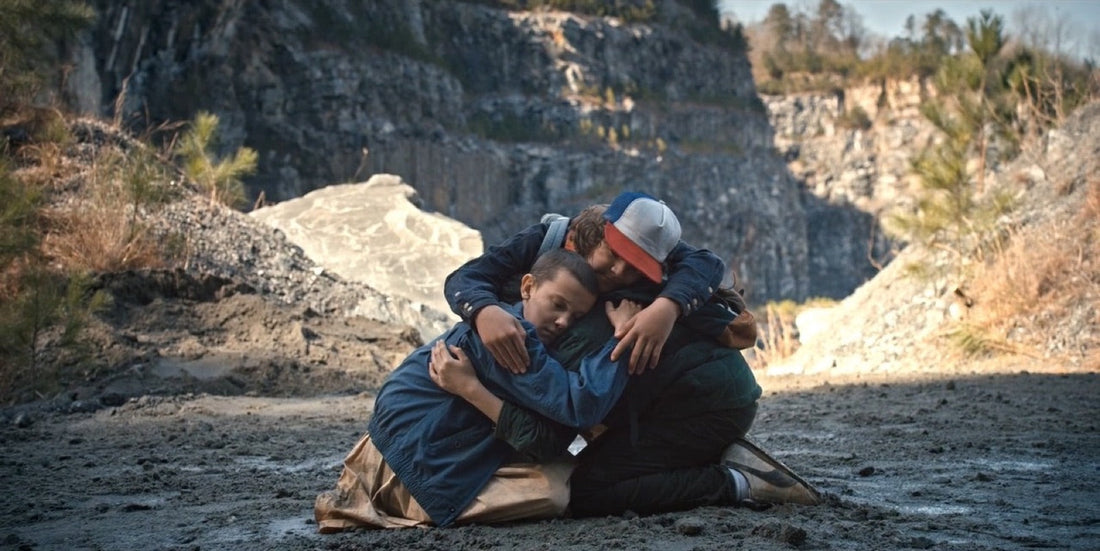 Tres chicos arrodillados y abrazados en el fondo de una cantera, Stranger Things temporada 1 episodio 6