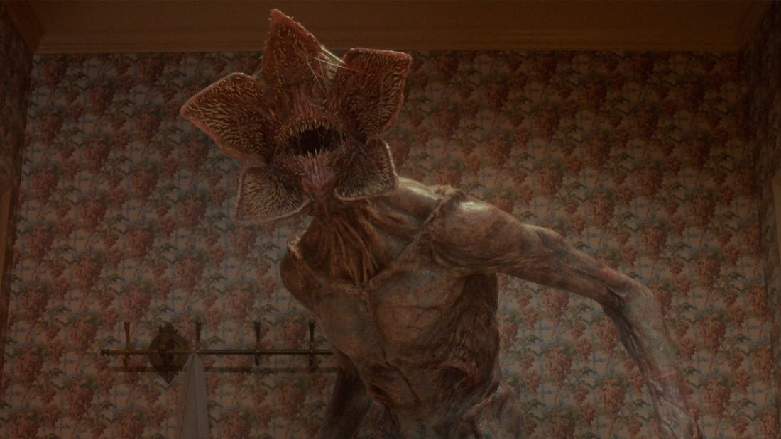 El Demogorgon, con la boca abierta, en una habitación de papel pintado floral