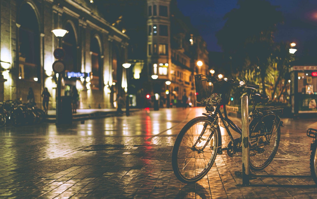 Calle de noche, farolas y bicicleta, luz naranja sobre el asfalto