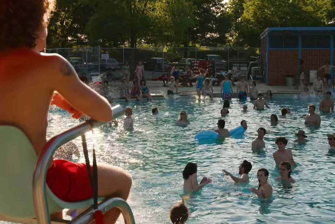 Piscina municipal llena, en verano, con la silla del socorrista en primer plano.