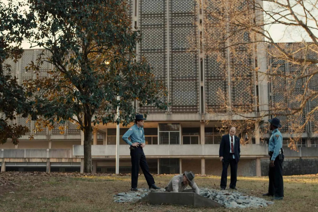 La policía de Hawkins alrededor de Jim Hopper, frente a un gran edificio
