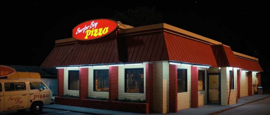 Restaurante de noche, furgoneta amarilla aparcada bajo el rótulo luminoso