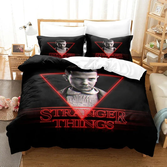 Juego de cama Stranger Things Once temporada 1 triángulo rojo sobre una cama, con sus fundas de almohada a juego