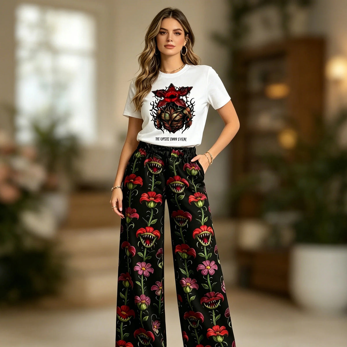 Mujer con el pijama Stranger Things, camiseta blanca de Demogorgon y pantalón ancho de flores